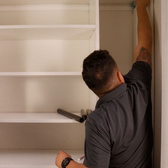 Professional installment technician at worksite, building closet shelving from California Closets
