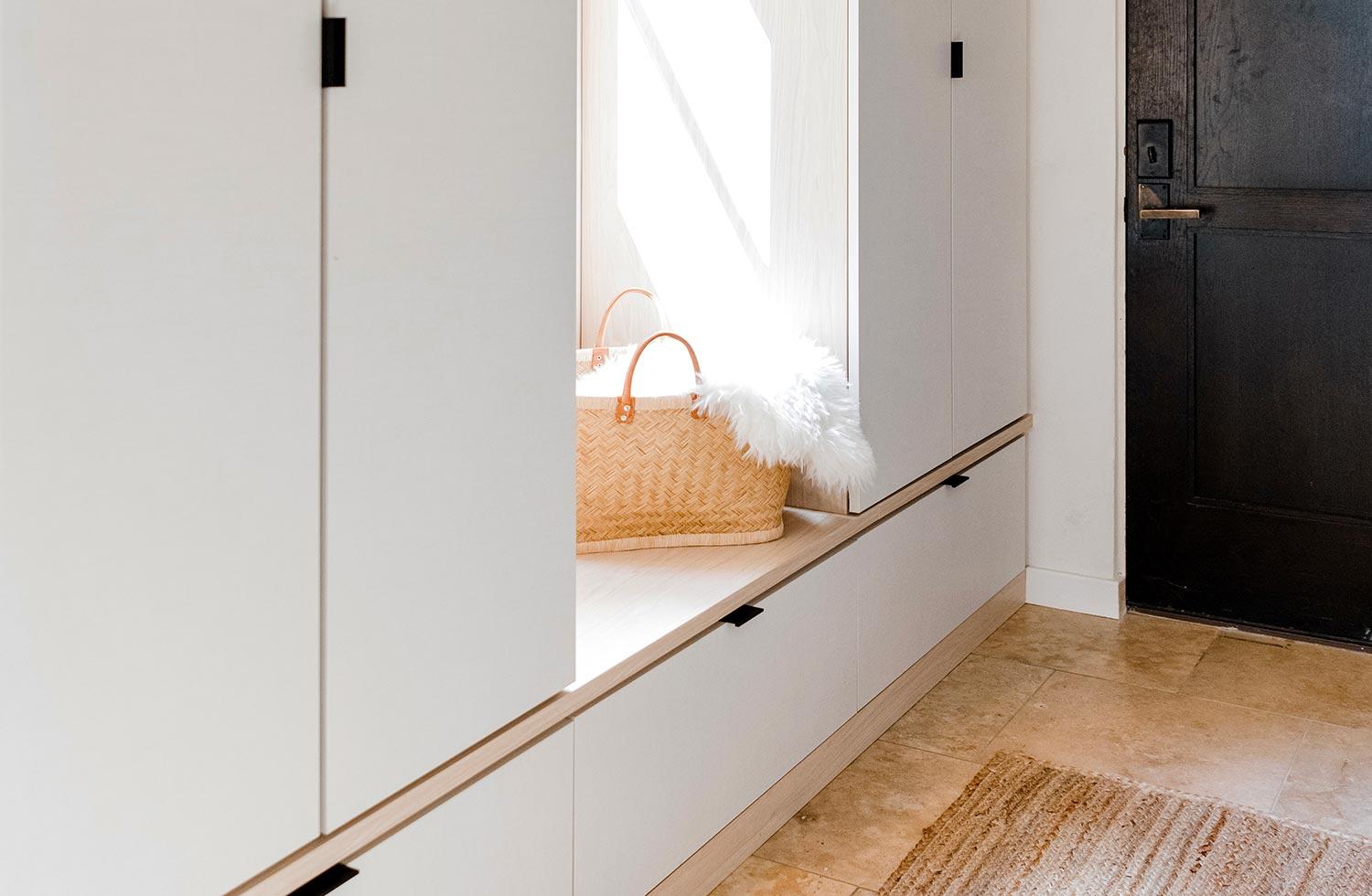 Entry cabinets in white finish with bench and custom drawers by California Closets