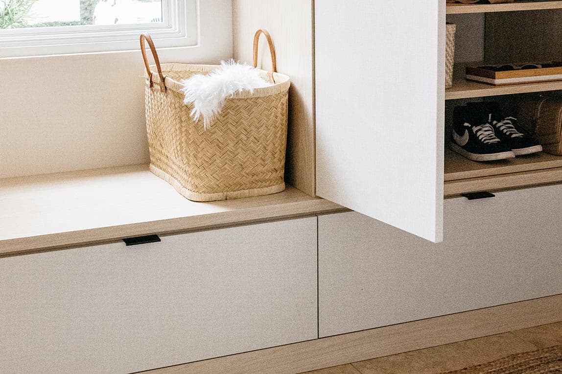 Custom cabinet, drawer and bench for mudroom entry created by California Closets