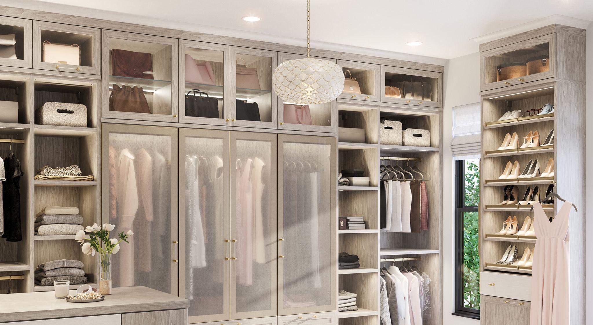 Walk in closet designed with decorative cabinet doors, vanity and desk by California Closets