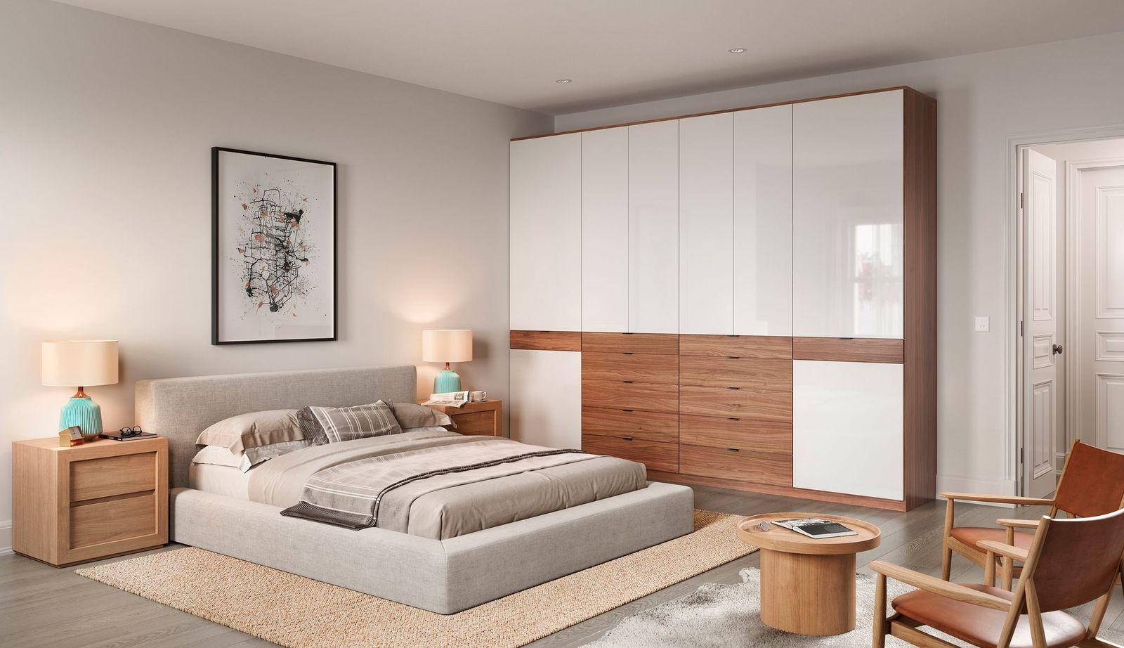 Newly installed wardrobe closet with custom cabinet storage in white gloss finish by California Closets