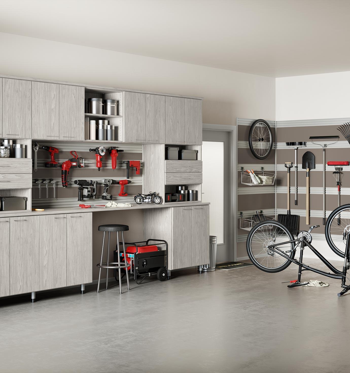 Custom garage storage solutions with bench, drawers, and workbench by California Closets