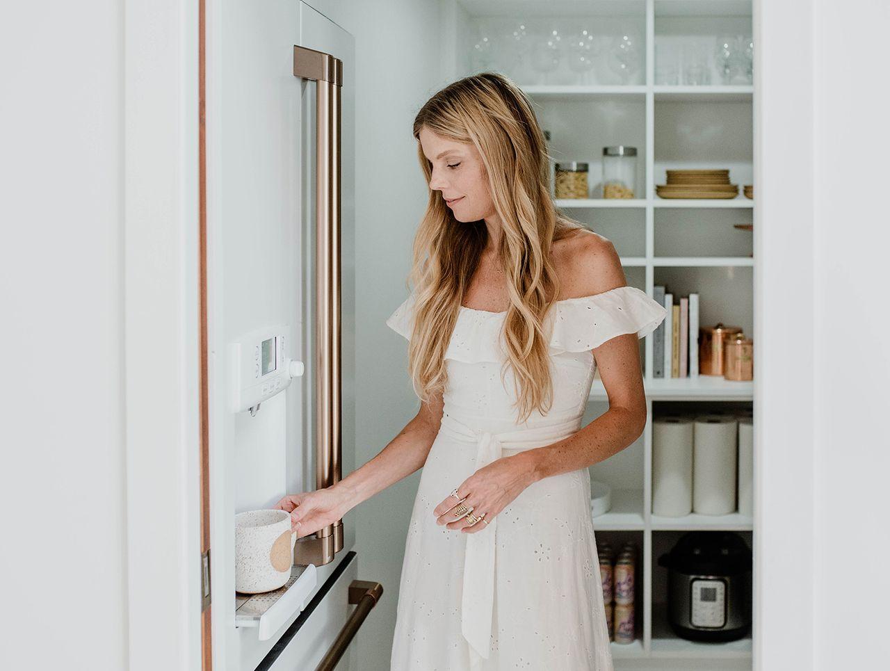 Sarah Sherman Samuel's kitchen pantry design with open shelving, pull out baskets and organizers in white finish by California Closets