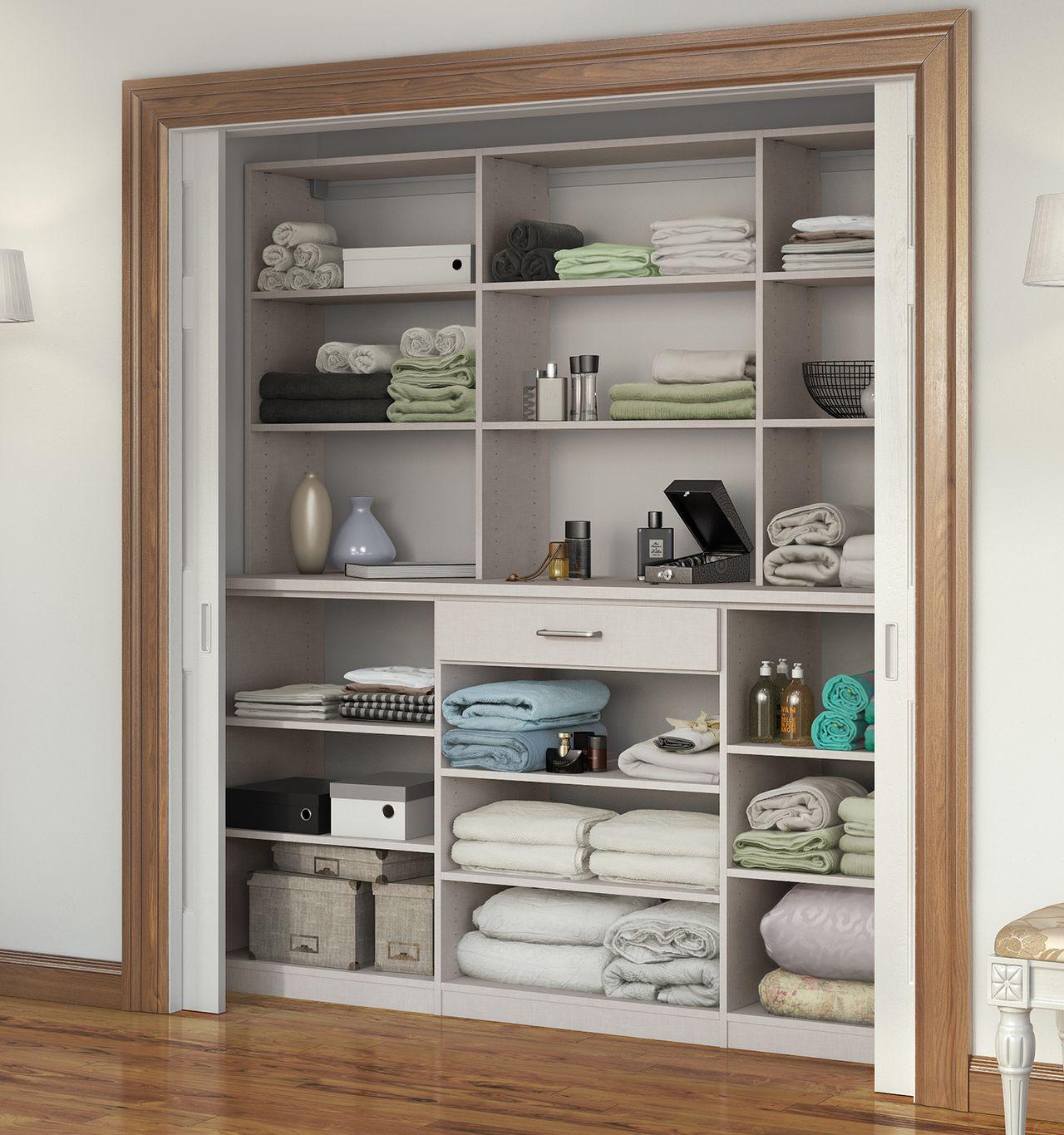 Elegant hall linen closet with light wood drawers, designed for functional storage by California Closets