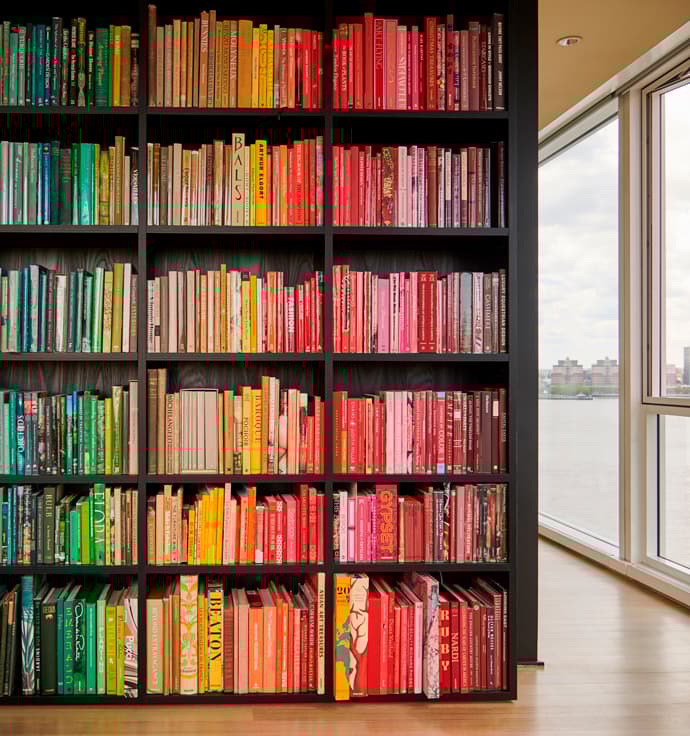 Custom built bookshelves designed to create room divider in dark wood finish created by California Closets