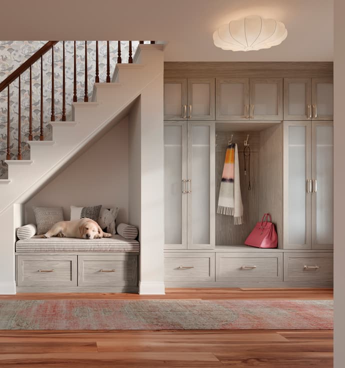 Foyer closet and storage bench and pet bed with tall closet glass door cabinets by California Closets
