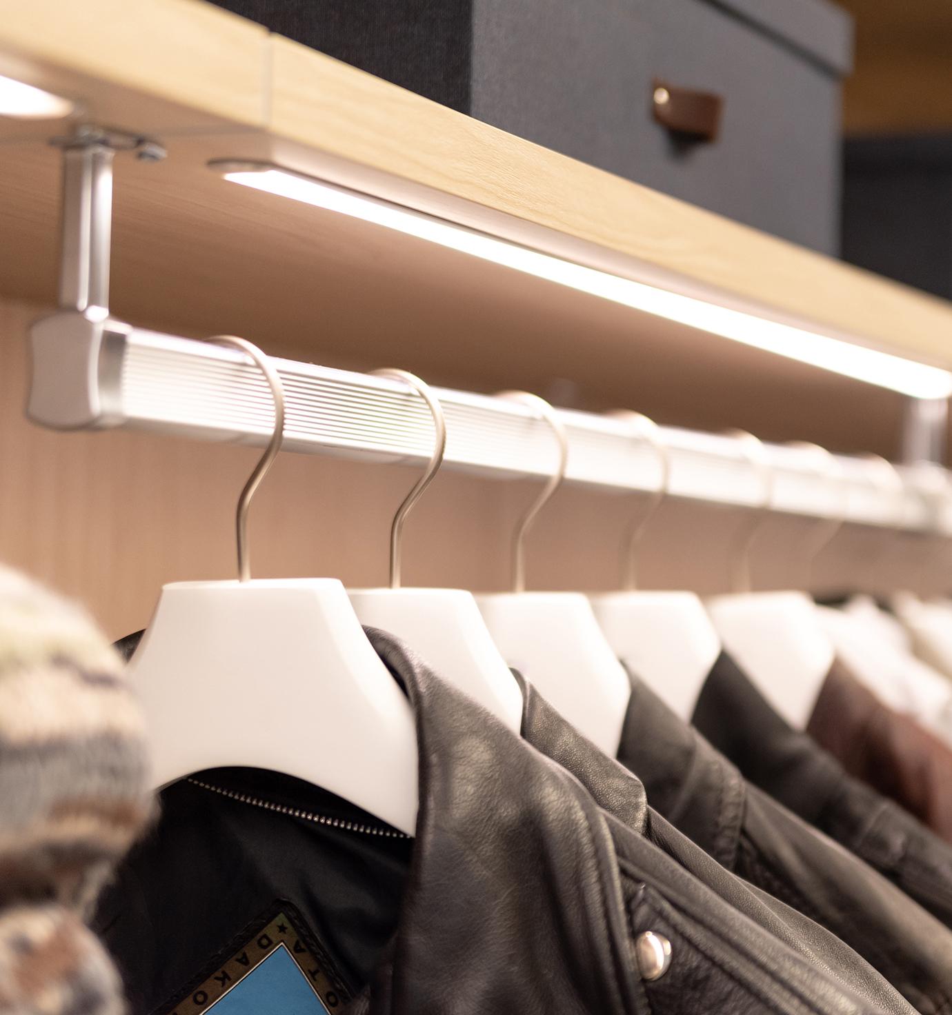 Custom closet clothing rods with lighting detail by California Closets