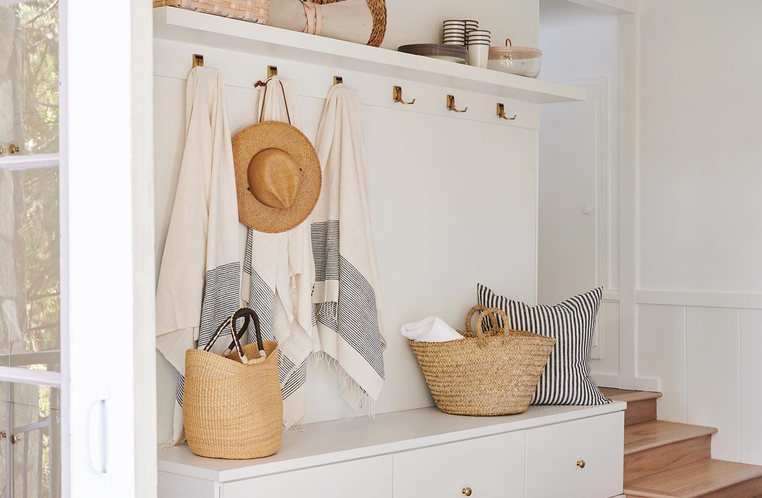 Entryway mudroom with bench seating and storage space in a white finish by California Closets