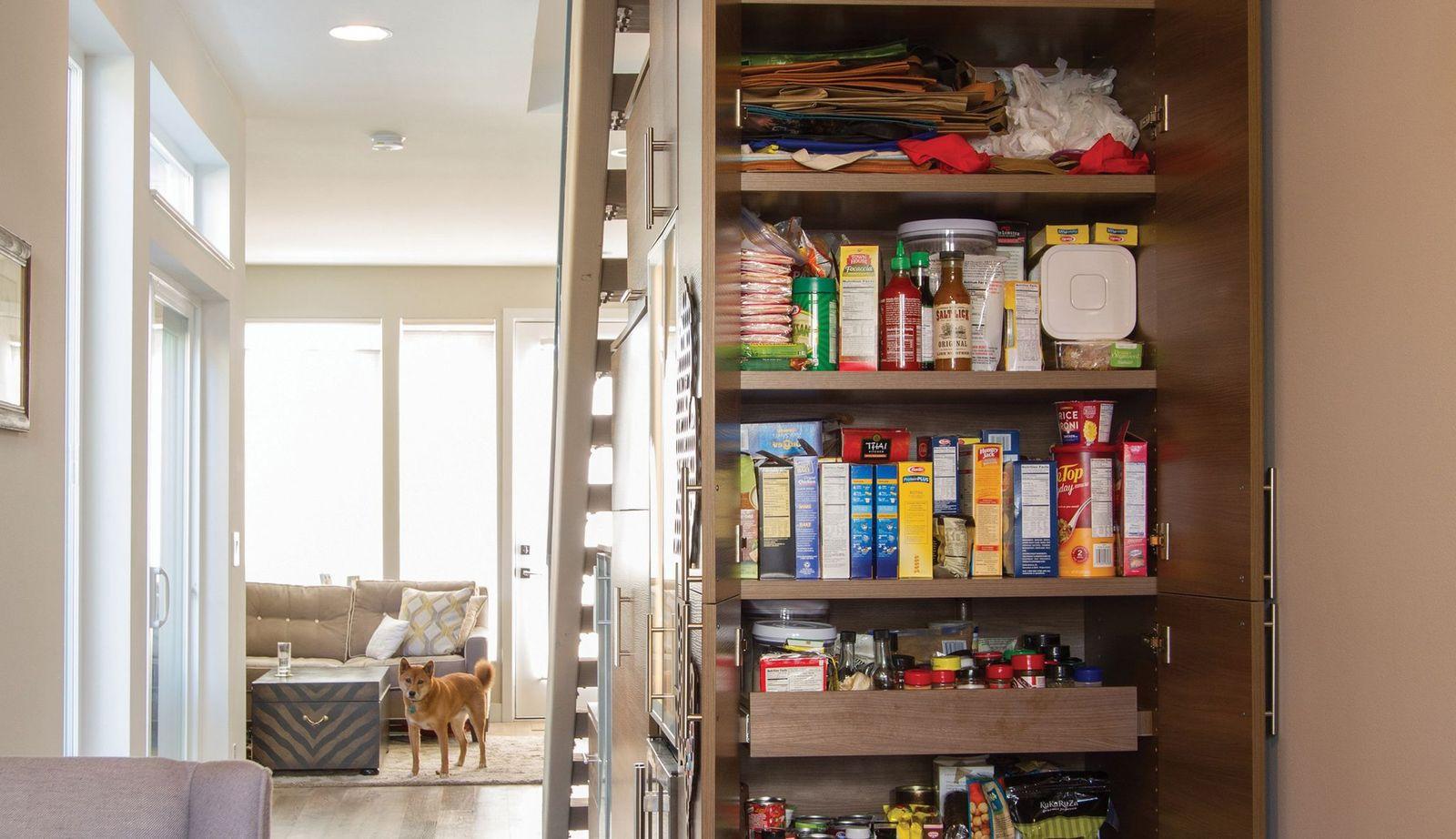 After image of custom kitchen pantry built in under stairwell with shelves and drawers in dark finish by California Closets