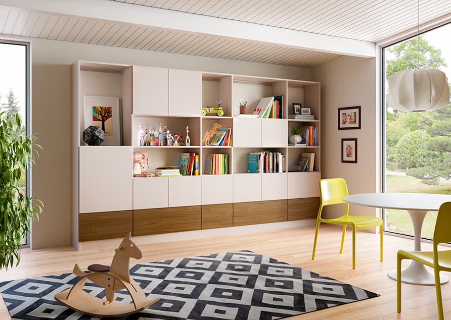 After renovated playroom storage with storage cabinets, bookcases, and open shelves in natural finishes by California Closets