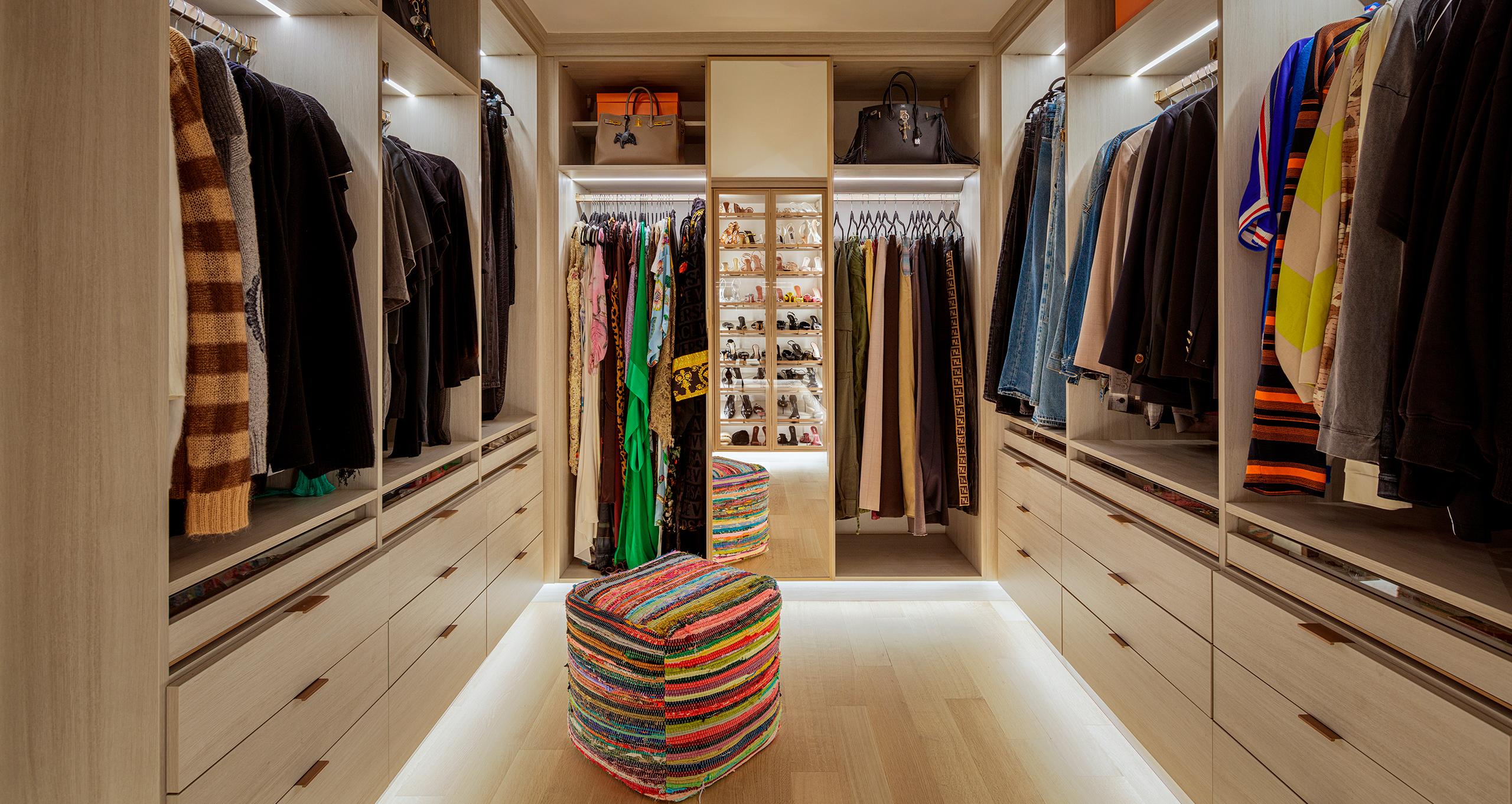 Walk-in closet featuring custom shelving, drawers, and elegant lighting designed for Ashley Graham in Northern New Jersey, from California Closets.