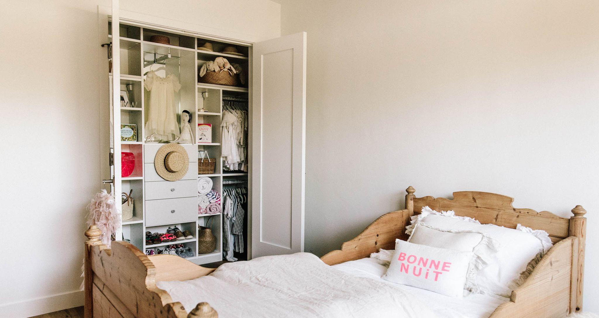 Kid's reach in closet with built in dresser drawers and shelving by California Closets