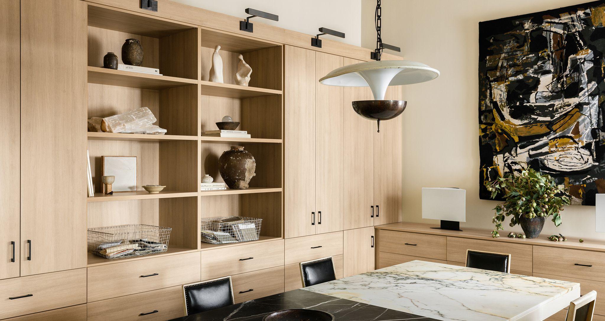 Interior designer, Jeremiah Brent’s custom office designed with cabinets, shelving and drawers in a light wood grain finish created by California Closets