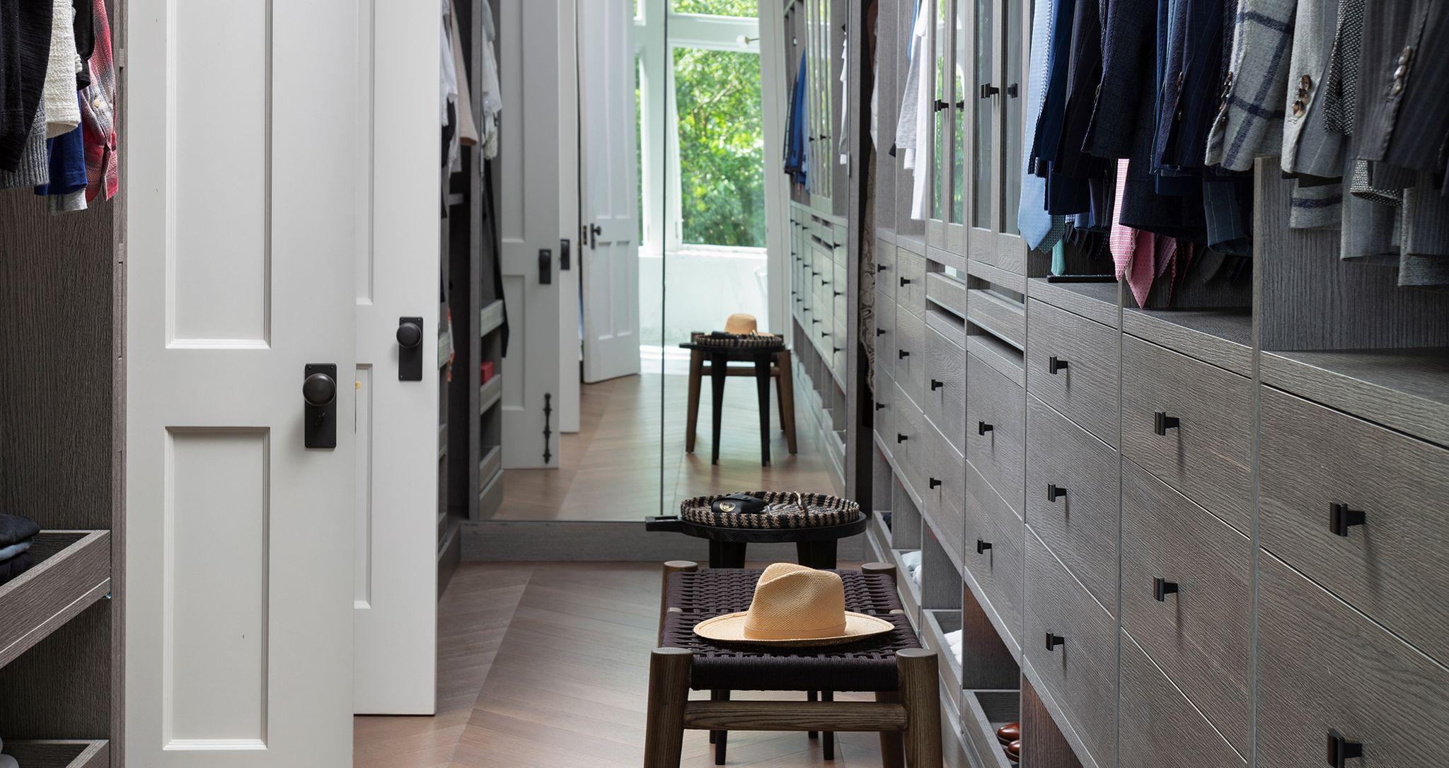 Custom walk in closet for Ryan Serhant with drawers, hanging storage and wall mirror by California Closets