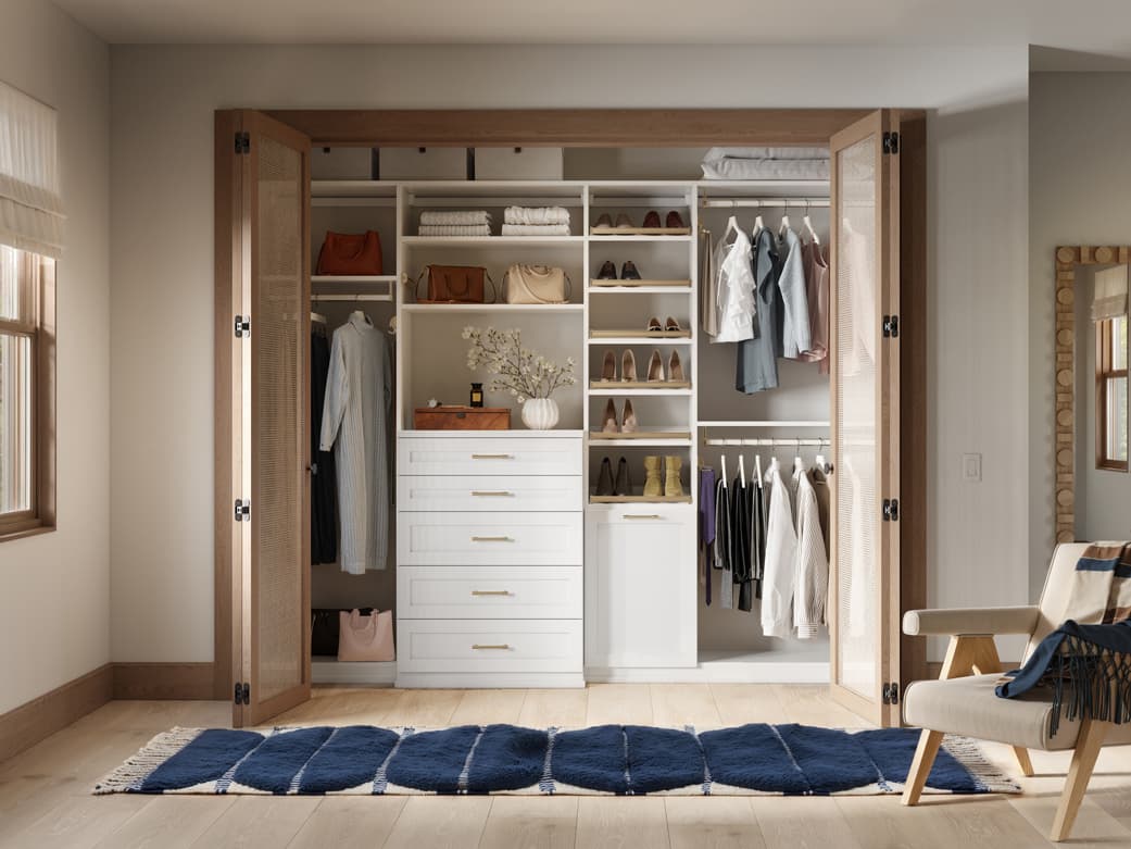 Light-toned reach in cubbies featuring drawers and integrated hamper by California Closets